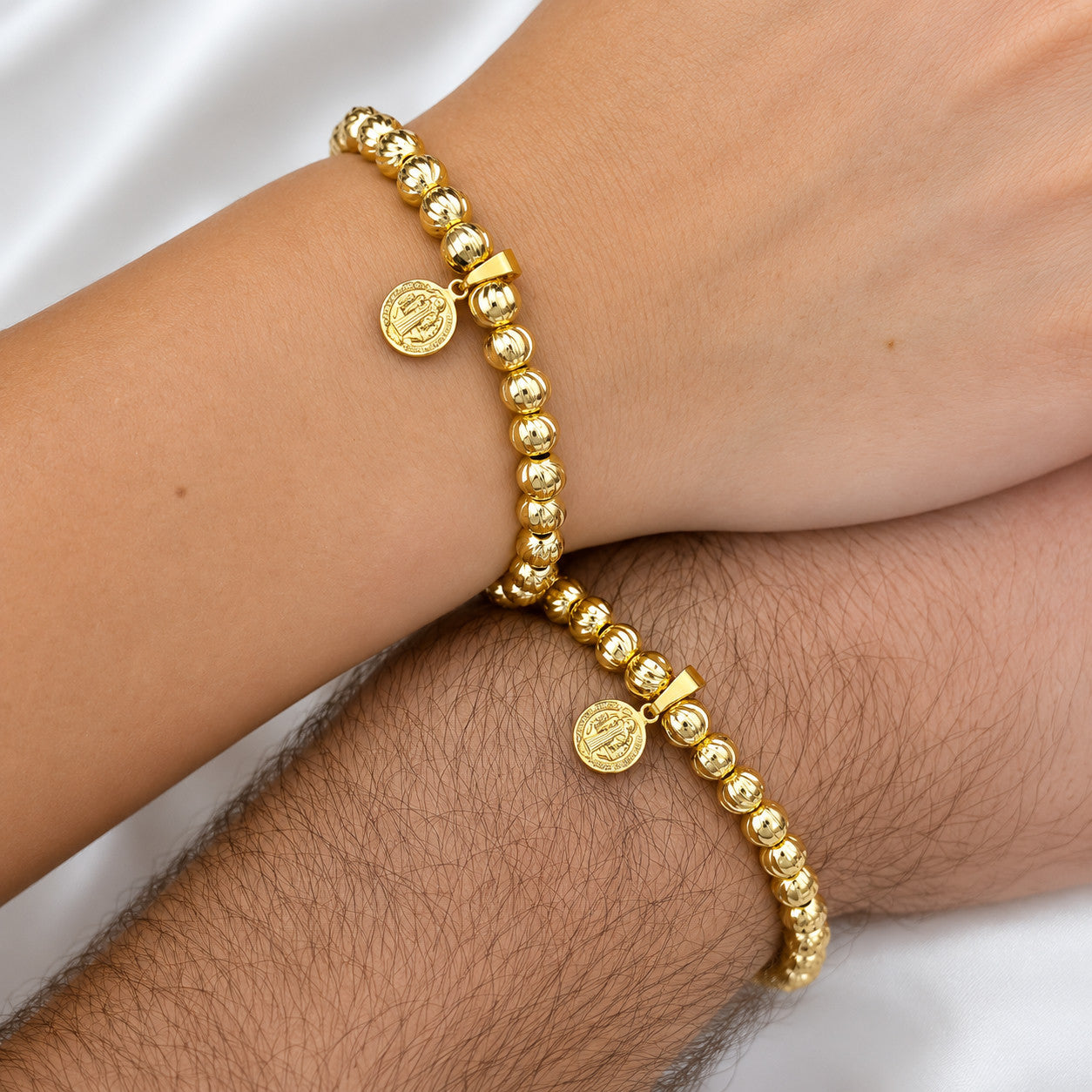 Dos pulseras italianas san benito oro laminado 18k puestas en pareja
