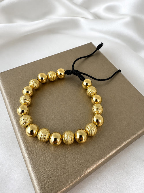 Pulsera oro laminado 18k balin 8mm sobre caja beige